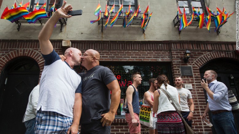 Doug Mest, left, and Mark Pelekakis kiss outside the Stonewall Inn in New York, the site of the 1969 Stonewall riots and an iconic bar in the LGBT community.