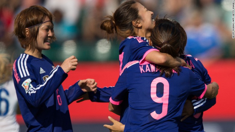 Japan players celebrate first-half goal against England on Wednesday in Edmonton.
