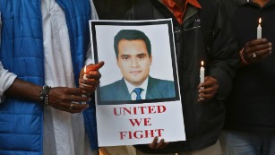 Indian journalists hold candles and a photograph of Akshay Singh during a memorial meeting in Bangalore, India, Monday, July 6, 2015. Singh, an Indian television journalist died under mysterious circumstances Saturday while on assignment covering allegations of a massive scheme to manipulate the results of entrance examinations for government jobs and medical colleges in the central Indian state of Madhya Pradesh. The alleged scam labeled &quot;Vyapam&quot; by Indian media after the Hindi name of the state&#39;s professional examination board since the story first surfaced in 2013. (AP Photo/Aijaz Rahi)