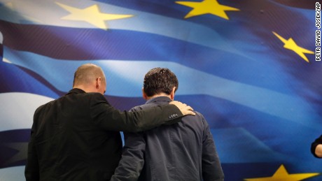 New Greek Finance Minister Euclid Tsakalotos, right, and outgoing Finance Minister Yanis Varoufakis leave together after a hand over ceremony in Athens, Monday, July 6, 2015. Despite triumphing in a popular referendum vote against austerity, Greece on Monday faced the urgent need to heal its ties with European creditors and reach a financial rescue deal that might prevent it from falling out of the euro,  (AP Photo/Petr David Josek)
