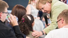 This Handout photo made available by the German government press office on July 16 2015 shows German Chancellor Angela Merkel (R) comforting a a crying Palestinian girl threatened with deportation on July 15, 2015 in Rostock, northern Germany. Merkel faced a social media storm after the release of a video showing her awkward interaction with the girl threatened with deportation as she addressed a public discussion with teenagers in the northern city of Rostock as part of a government-initiated series called &quot;Living Well in Germany&quot;. AFP PHOTO / HO / BUNDESREGIERUNG / STEFFEN KUGLER