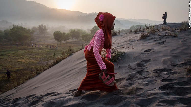 A Muslim woman walks on &#39;sea of sands&#39; as they prepare for  prayer at Parangkusumo beach  in Yogyakarta, Indonesia. 