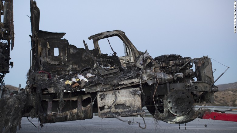 The scorched remains of a truck destroyed by the North Fire, are towed away from the scene on July 17 near Victorville.