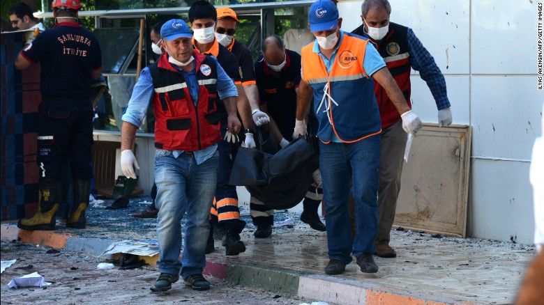 Officials carry the bodies of victims on July 20, 2015 after an explosion in the town of Suruc, not far from the Syrian border.