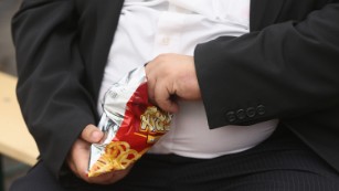 LEIPZIG, GERMANY - MAY 23: A man with a large belly eats junk food on May 23, 2013 in Leipzig, Germany. According to statistics a majority of Germans are overweight and are comparatively heavier than people in most other countries in Europe. (Photo by Sean Gallup/Getty Images) 