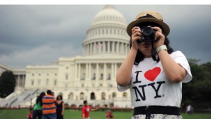 A tourist snaps pictures on the West lawn of the US Capitol