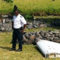 A policeman and a gendarme stand next to a piece of debris from an unidentified aircraft found in the coastal area of Saint-Andre de la Reunion, in the east of the French Indian Ocean island of La Reunion, on July 29, 2015. The two-metre-long debris, which appears to be a piece of a wing, was found by employees of an association cleaning the area and handed over to the air transport brigade of the French gendarmerie (BGTA), who have opened an investigation. An air safety expert did not exclude it could be a part of the Malaysia Airlines flight MH370, which went missing in the Indian Ocean on March 8, 2014. AFP PHOTO / YANNICK PITONYANNICK PITON/AFP/Getty Images