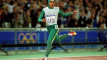 Cathy Freeman delighted Australian fans by winning the women's 400m, becoming the first athlete to light the Olympic torch and take a gold medal at the same Games.