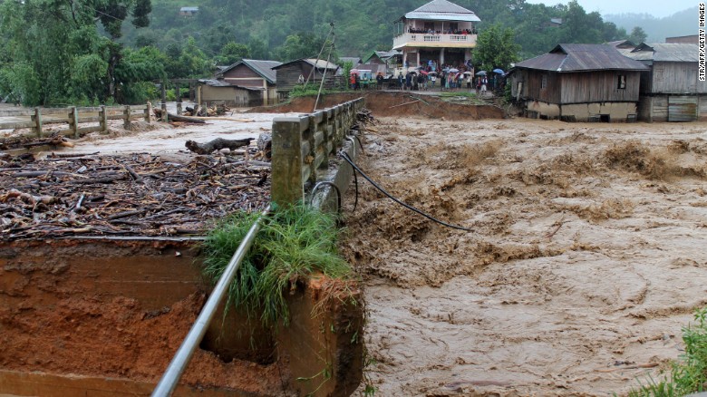 People look at a bridge which was washed away by floodwater in the state of Manipur, India on August 1, 2015. At least 178 have been killed in recent flooding, with an estimated 10 million affected across India.