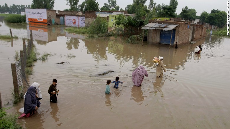 Pakistani villagers wade through floodwaters caused by heavy rains at a village on the outskirts of Nowshera near Peshawar, Pakistan, Sunday, Aug. 2, 2015. Flooding has left millions displaced throughout the region.