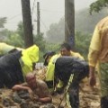 Emergency rescue personnel dig a man from a flash mudslide caused by Typhoon Soudelor in Xindian, New Taipei City, Taiwan, on Saturday, August 8.