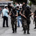 Turkish special force police officers take cover during clashes with attackers on August 10, 2015 at the Sultanbeyli district in Istanbul. Turkey&#39;s largest city Istanbul was Monday shaken by twin attacks on the US consulate and a police station as tensions spiral amid the government&#39;s air campaign against Kurdish militants.