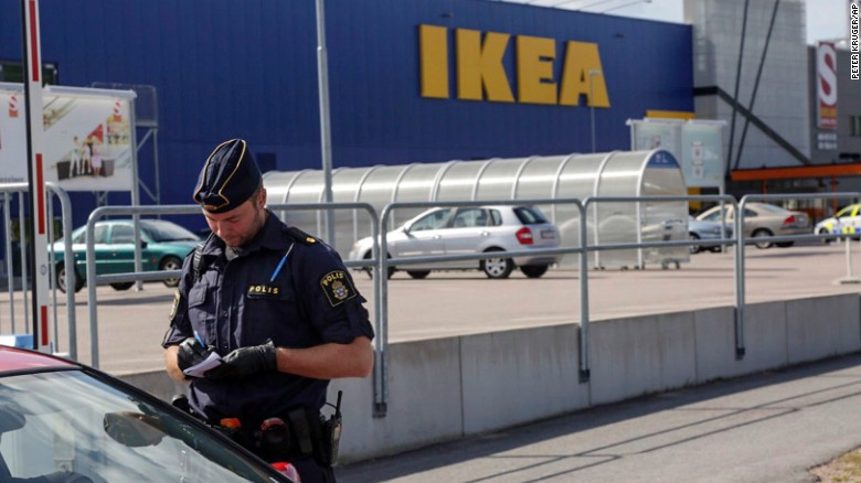 A police officer talks to customers outside the IKEA store in Vasteras, Sweden, after Monday&#39;s knife attack.