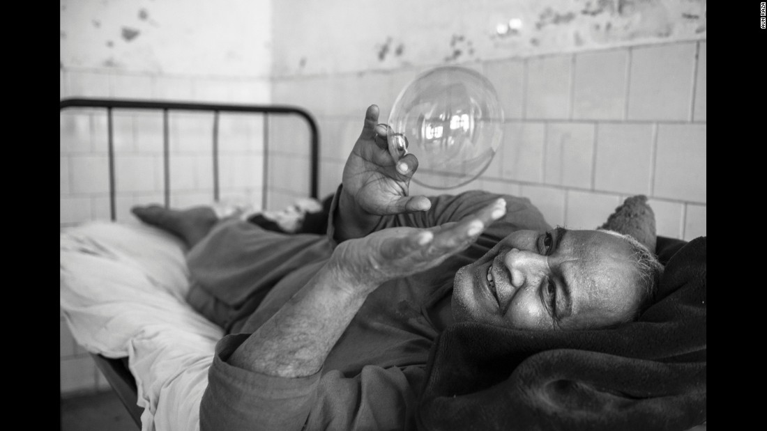 A patient plays with a soap bubble inside a mental hospital in Lahore, Pakistan. Photographer Aun Raza documented the lives of patients there from 2011 to 2014.