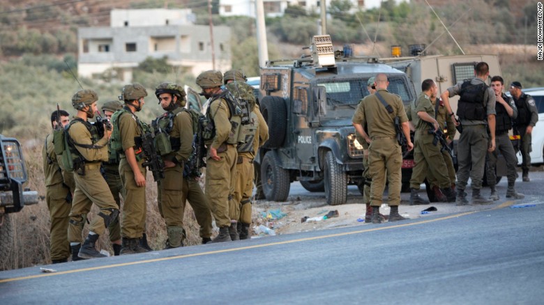 Israeli soldiers gather after a Palestinian was shot and killed by an Israeli policeman after he stabbed a policeman, in the village of Beita south of the West Bank city of Nablus.