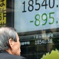 An investor watches a share prices board in Tokyo on August 24. Japan's share prices dropped 623.34 points at the Tokyo Stock Exchange, swept lower in a global equities rout as worries about China's economy deepen.