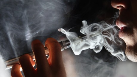 LONDON, ENGLAND - AUGUST 27:  In this photo illustration, a man smokes an E-Cigarette at the V-Revolution E-Cigarette shop in Covent Garden on August 27, 2014 in London, England. The Department of Health have ruled out the outlawing of 'e-cigs' in enclosed spaces in England, despite calls by WHO, The World Health Organisation to do so. WHO have recommended a ban on indoor smoking of e-cigs as part of tougher regulation of products dangerous to children.  (Photo by Dan Kitwood/Getty Images)