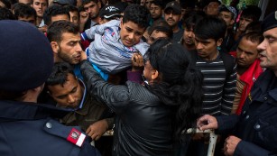 A woman holds a child as hundreds of refugees try to board a train to Vienna at the railway station in Nickelsdorf, Austria, after crossing the Hungarian-Austrian border on September 5. Thousands of refugees stream into Austria from Hungry by the day as Europe continues to grapple with its biggest influx of refugees since WWII.