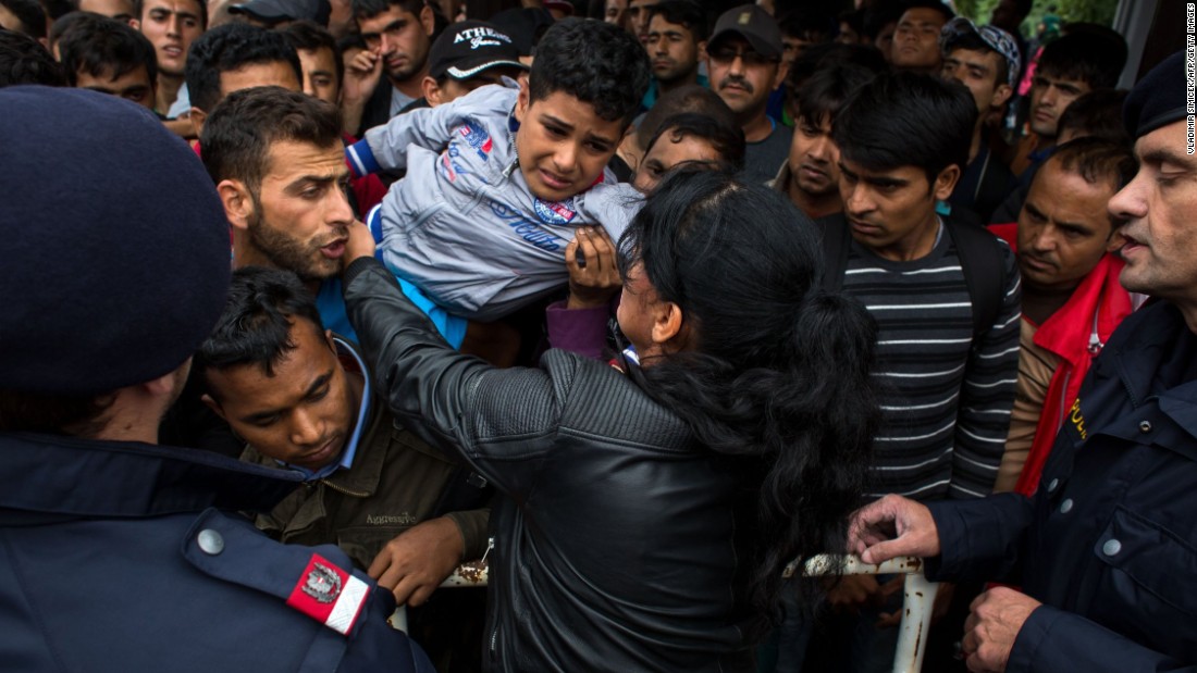 A woman holds a child as hundreds of refugees try to board a train to Vienna at the railway station in Nickelsdorf, Austria, after crossing the Hungarian-Austrian border on September 5. Thousands of refugees stream into Austria from Hungry by the day as Europe continues to grapple with its biggest influx of refugees since WWII.