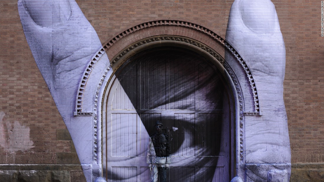 Liu Bolin collaborated with French street artist JR on this work. Liu hides himself in one of JR's large-scale murals in New York City.<br /></noscript>” width=”711″ height=”400″ /></p>
<p></p>
<p class=