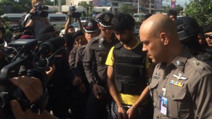  Yusufu Meerailee, one of the suspects, wears a bulletproof vest as he is escorted by Thai authorities.