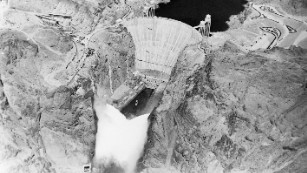 12 Sep 1936, USA --- Original caption: 9/12/1936-Boulder Dam, AZ/NV- An electrical impulse released by President Roosevelt pressing a button across the continent sent 3,600,000 cubic feet of water a minute tumbling through Gigantic Boulder Dam, and put the Colorado River to work generating electrical power. This photo made by Albert Kopec from a Richfield Oil Company plane, shows the Niagara of water from the 12 outlets; six on the Nevada side and six on the Arizona side. --- Image by © Bettmann/CORBIS