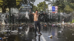 A man reacts after Hungarian riot police use water cannon to push back refugees at the Hungary-Serbia border near the Serbian town of Horgos on September 16.