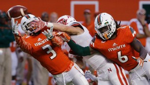 Miami defensive back Tracy Howard (3) and defensive back Jamal Carter (6) break up a pass intended for Nebraska wide receiver Brandon Reilly during the second half of an NCAA college football game, Saturday, Sept. 19, 2015 in Miami Gardens, Fla. Miami defeated Nebraska 36-33 in overtime. (AP Photo/Wilfredo Lee)