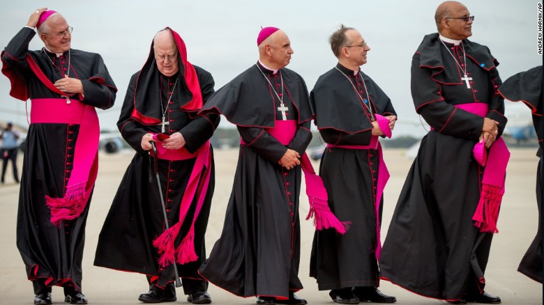 Clergy members brace for the wind as they stand on the tarmac at Andrews Air Force Base.