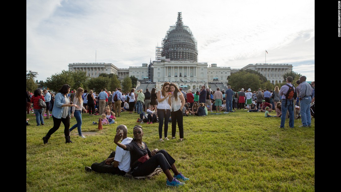 People gather in front of the U.S. Capitol building in Washington to watch a telecast of Pope Francis addressing a joint session of Congress on Thursday, September 24.