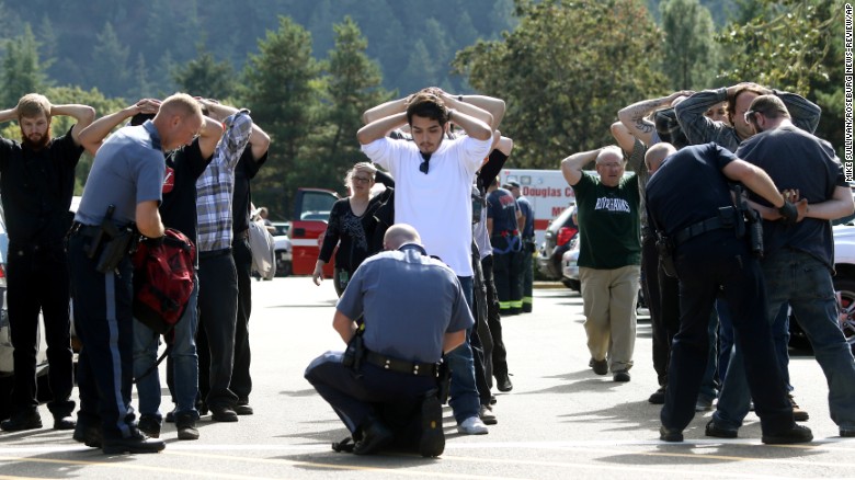 Police search students outside the school on October 1.