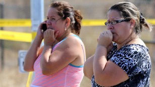 Two woman wait outside Umpqua Community College after a shooting at the school in Roseburg, Oregon, on October 1, 2015.