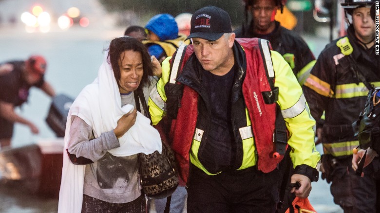 Charlene Stennis is escorted to safety after her son was rescued from a stranded vehicle during the heavy rains on October 4 in Columbia, South Carolina. 