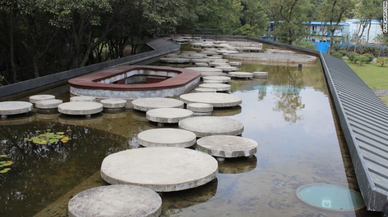Concrete &quot;pads&quot; act as stepping stones guiding visitors to a hidden spiral stairwell that takes them down into the house of Pond Lily. 