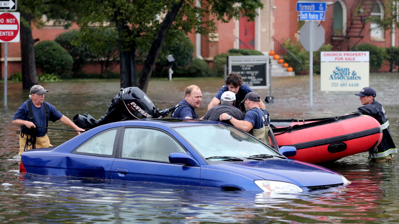 Members of Norfolk Fire-Rescue pull a man from his car in Norfolk, Virginia, on Sunday, October 4.