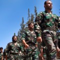 TO GO WITH AFP STORY BY ANTONIO PAMPLIEGA - Members of rebel brigades parade during a ceremony to mark an agreement to unite the of forces Liwaa al-Tawid and Liwad al- Fatah brigades on September 13, 2013 at a former military academy north of Aleppo. Syrian rebels have expressed disdain for US President Barack Obama after he backed away from striking over alleged chemical weapons attacks, while saying the world doesn't really care about Syria.     AFP PHOTO JM LOPEZ        (Photo credit should read JM LOPEZ/AFP/Getty Images)