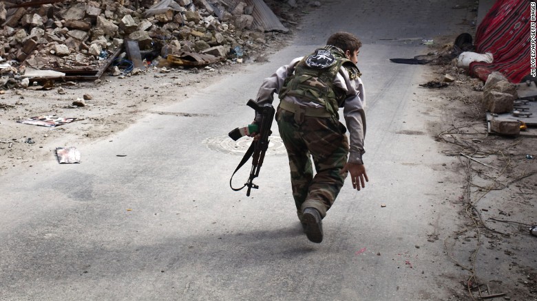 A Syrian rebel crosses a street while trying to dodge sniper fire in the old city of Aleppo in northern Syria on March 11, 2013. Syria warned on March 12 it is ready to fight &quot;for years&quot; against rebels, as world powers worked on a new initiative to find regime officials suitable for peace talks with the opposition. AFP PHOTO/JM LOPEZ (Photo credit should read JM LOPEZ/AFP/Getty Images)