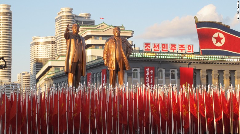 North Korean soldiers march below statues of North Korean founder Kim Il Sung and his son, Kim Jong Il.