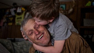 Skylor Cox, 3, jumps on his father's back to give him "little kissies" at their home in Fordsville, Ky., on February 15, 2014.
"You've gotta be close with your little ones. When your kids get grown you lose them. You lose that certain part of them," Faron said. 