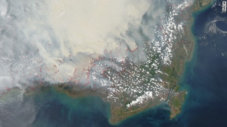 NASA&#39;s satellite captured this image of heavy smoke blanketing Borneo on October 19, 2015. The red outlines indicate areas where unusually warm surface temperatures associated with peat fires are detected.