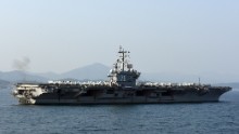 Sailors aboard the U.S. Navy's only forward-deployed aircraft carrier, the Nimitz-class USS Ronald Reagan (CVN 76), man the rails while participating in the South Korean Navy's Fleet Review on October 23 in Busan.