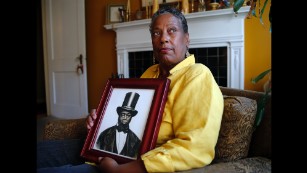 Ocea Thomas poses for a portrait with a picture of her ancestor Samuel Burris in Atlanta. Deleware Gov. Jack Markell will pardon Burris, a free black man and conductor on the Underground Railroad who died in 1863. Burris was convicted of helping slaves escape to freedom in the 19th century.