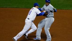 Daniel Murphy  of the New York Mets tags Salvador Perez of the Kansas City Royals prior to completing a double play in the eighth inning.