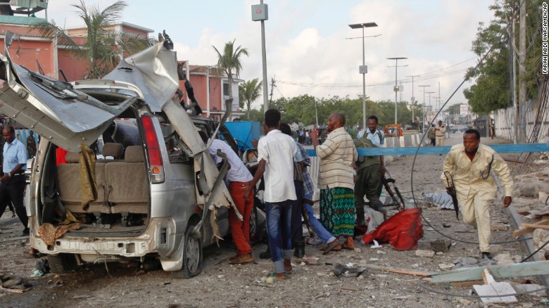A Somali policeman runs through the wreckage outside the Sahafi Hotel in Mogadishu.