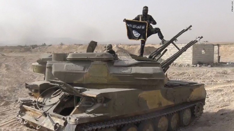 In this image taken from social media, an ISIS fighter holds the group&#39;s flag as he stands on a tank, purportedly captured when they took over the town of Qaryatain, Syria. ISIS is one of two groups accounting for 51% of claimed terrorism deaths in 2014. 