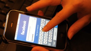 A Malaysian proffesional enters her Facebook password.