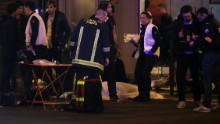 Rescue workers and medics tend to victims at the scene of one of the shootings, a restaurant in the 10th District. Attackers reportedly used AK-47 automatic weapons in separate attacks across Paris, and there were explosions at the Stade de France.