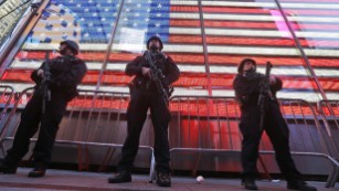 Heavily armed New York city police officers with the Strategic Response Group stand guard at the armed forces recruiting center in New York's Times Square, Saturday, Nov. 14, 2015.  Police in New York say they've deployed extra units to crowded areas of the city "out of an abundance of caution" in the wake of the attacks in Paris, France. A New York Police Department statement released Friday stressed police have "no indication that the attack has any nexus to New York City." (AP Photo/Mary Altaffer)