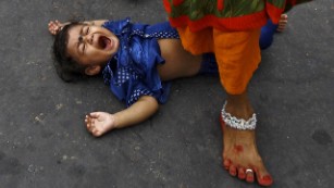 Image #: 40900687    A Hindu woman steps over a child in a ritual seeking blessings for the child from the Sun god Surya during the Hindu religious festival of Chatt Puja in Kolkata, India, November 17, 2015. Hindu women fast for the whole day for the betterment of their family and the society during the festival. REUTERS/Rupak De Chowdhuri      TPX IMAGES OF THE DAY      /LANDOV