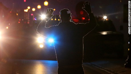 FERGUSON, MO - NOVEMBER 24:  A protestor stands in front of police vehicles with his hands up during a demonstration on November 24, 2014 in Ferguson, Missouri. A St. Louis County grand jury has decided to not indict Ferguson police Officer Darren Wilson in the shooting of Michael Brown that sparked riots in Ferguson, Missouri in August.  (Photo by Justin Sullivan/Getty Images)